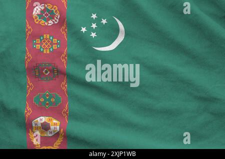 Turkmenistan-Flagge auf gefaltetem, gewelltem Stoff aus altem Tuch in Nahaufnahme dargestellt Stockfoto