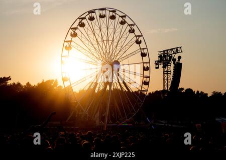 Nordholz, Deutschland. Juli 2024. Die Sonne untergeht hinter einem Riesenrad auf dem Festivalgelände des Deichbrand Festivals. Das Open-Air-Festival mit rund 60.000 Besuchern findet vom 18. Bis 21. Juli statt. Quelle: Hauke-Christian Dittrich/dpa/Alamy Live News Stockfoto