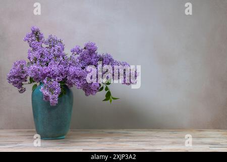 Ein riesiger Fliederstrauß in einer großen Vase, isoliert auf einem hellgrauen Hintergrund. Stillleben mit Blumen, viel Platz für Text Stockfoto