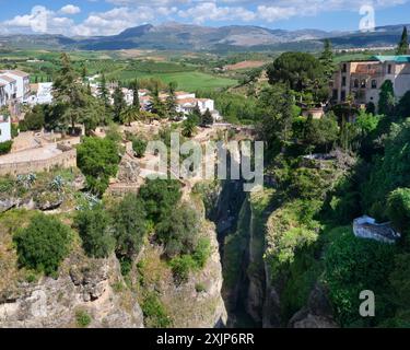 Ein Panoramablick von oberhalb der Puento Viejo Brücke, die den Fluss in der tiefen Schlucht zwischen den beiden Seiten von Ronda Spanien überspannt. Stockfoto