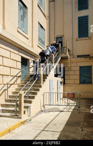 Besucher verlassen den Erholungshof im Freien auf der Westseite des D-Blocks auf dem Alcatraz Prison; Alcatraz Island, San Francisco, Kalifornien. Stockfoto