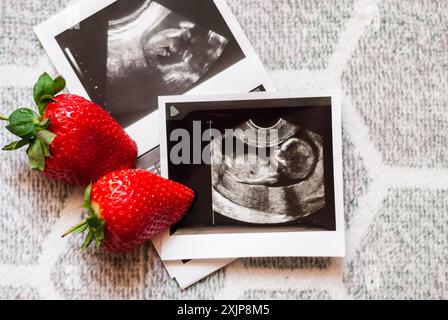 Erdbeeren und Foto des Fetus (Ultraschalluntersuchung während der Schwangerschaft) Baby wartet. Baby mit IVF. Infertilitätsbehandlung. Die künstliche Besamung Stockfoto