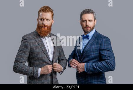 Zwei Männer in eleganter Herrenmode mit Anzug und Schleife isoliert auf Grau Stockfoto
