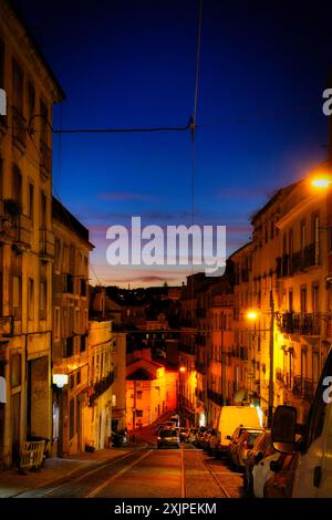 Blick von den Hügeln des alfama-Viertels in lissabon entlang einer der steilen Straßen bis zur blauen Stunde Stockfoto