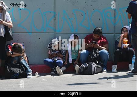 Tijuana, Baja California, Mexiko. Juli 2024. Fußgänger warteten vier bis acht Stunden, während einige sich vor der heißen Sonne bedeckten, um am Freitag, den 19. Juli 2024, am San Ysidro Port of Entry Grenzübergang in Tijuana, Mexiko, in die Vereinigten Staaten zu überqueren. Ein verpfuschtes Software-Update des Cybersicherheitsunternehmens CrowdStrike Holdings Inc. Stürzte weltweit unzählige Microsoft Windows-Computersysteme ab und wirkte sich auf die CBP One-App aus, die von Menschen über die Grenze zwischen den USA und Mexiko verwendet wurde. (Kreditbild: © Carlos A. Moreno/ZUMA Press Wire) NUR REDAKTIONELLE VERWENDUNG! Nicht für kommerzielle ZWECKE! Stockfoto