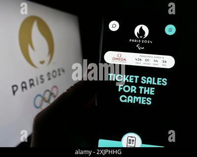 Stuttgart, Deutschland, 19.06.2023: Handybesitzer mit Webseite der Olympischen Sommerspiele 2024 in Paris vor dem Logo. Konzentrieren Sie sich auf Stockfoto