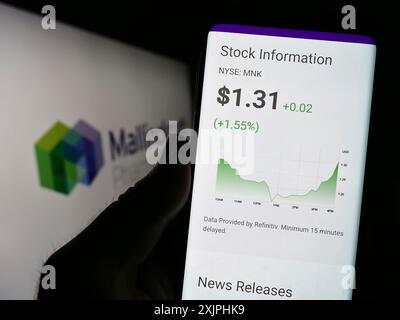 Stuttgart, 24.06.2023: Person, die ein Mobiltelefon hält, mit Website der Firma Mallinckrodt Pharmaceuticals plc auf dem Bildschirm vor dem Logo. Stockfoto