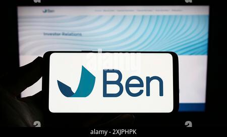 Stuttgart, 24.06.2023: Person mit Smartphone mit Logo der Beneficient Company Group (Trustben) auf dem Bildschirm vor der Website. Fokus Stockfoto