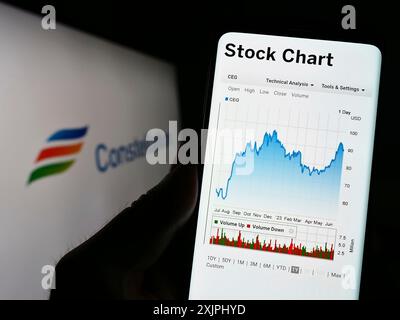 Stuttgart, 25.06.2023: Person, die ein Mobiltelefon hält, mit Website der US-amerikanischen Firma Constellation Energy Corporation auf dem Bildschirm vor dem Logo. Stockfoto