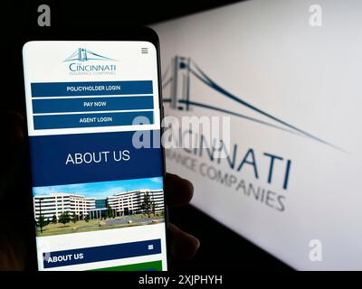 Stuttgart, Deutschland: 25.06.2023: Person, die ein Mobiltelefon hält, mit Website des US-amerikanischen Unternehmens Cincinnati Financial Corporation auf dem Bildschirm mit Logo. Fokus Stockfoto