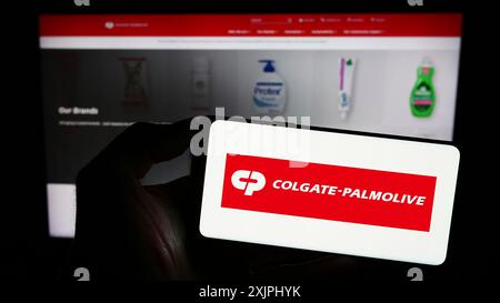 Stuttgart, 25.06.2023: Person mit Smartphone und Logo des Konsumgütergeschäfts Colgate-Palmolive Company auf dem Bildschirm Stockfoto