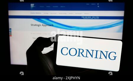 Stuttgart, 25.06.2023: Person mit Smartphone und Logo des US-amerikanischen Technologieunternehmens Corning Incorporated auf dem Bildschirm vor der Website. Stockfoto