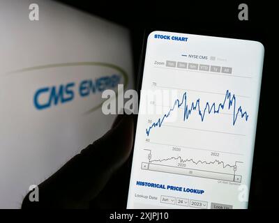 Stuttgart, Deutschland: 25.06.2023: Person, die ein Mobiltelefon hält, mit Website des US-Energieversorgers CMS Energy Corporation auf dem Bildschirm mit Logo. Konzentrieren Sie sich auf Stockfoto