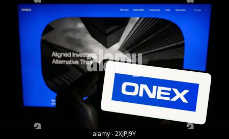Stuttgart, Deutschland, 07.01.2023: Person, die ein Smartphone mit dem Logo der kanadischen Investmentgesellschaft Onex Corporation auf dem Bildschirm vor der Website hält. Stockfoto