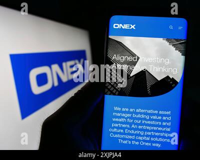 Stuttgart, Deutschland, 07.01.2023: Person mit Smartphone mit Website der kanadischen Investmentgesellschaft Onex Corporation auf dem Bildschirm mit Logo. Konzentrieren Sie sich auf Stockfoto