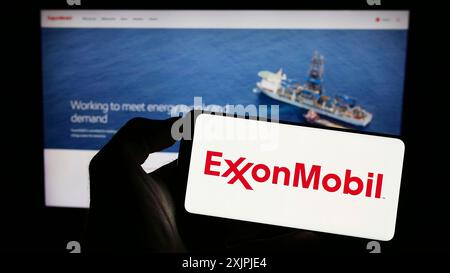 Stuttgart, Deutschland, 07.01.2023: Person, die ein Mobiltelefon mit dem Logo des amerikanischen Erdölunternehmens Exxon Mobil Corporation auf dem Bildschirm hält Stockfoto