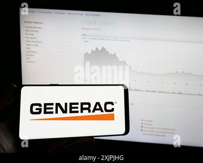 Stuttgart, Deutschland, 07.01.2023: Person, die ein Mobiltelefon mit dem Logo des amerikanischen Unternehmens Generac Holdings Inc. Auf dem Bildschirm vor dem Business Web hält Stockfoto
