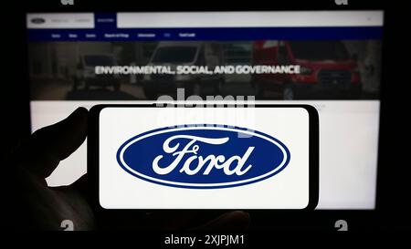 Stuttgart, Deutschland, 07.01.2023: Person, die ein Mobiltelefon mit dem Logo des amerikanischen Automobilherstellers Ford Motor Company auf dem Bildschirm vor der Webseite hält. Stockfoto