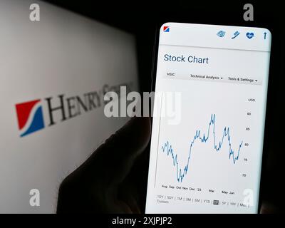 Stuttgart, Deutschland, 07-02-2023: Person, die ein Smartphone hält, mit der Webseite des US-amerikanischen Unternehmens Henry Schein Inc. Auf dem Bildschirm mit Logo. Fokus Stockfoto