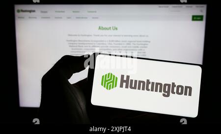 Stuttgart, Deutschland, 07.02.2023: Person, die ein Smartphone mit dem Logo des US-amerikanischen Unternehmens Huntington Bancshares Incorporated auf dem Bildschirm vor der Website hält. Stockfoto