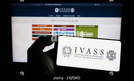 Stuttgart, Deutschland, 07.02.2023: Person mit Smartphone mit Logo der italienischen Versicherungsaufsichtsbehörde IVASS auf dem Bildschirm vor der Website. Stockfoto