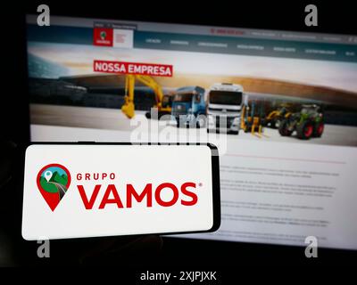 Stuttgart, Deutschland, 07.06.2023: Person, die ein Smartphone mit dem Logo des brasilianischen Lkw-Vermieters Grupo Vamos auf dem Bildschirm vor der Website hält. Stockfoto