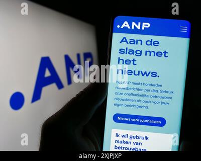 Stuttgart, Deutschland, 07.06.2023: Person mit Smartphone und Website von Algemeen Nederlands Persbureau B.V. (ANP) auf dem Bildschirm vor dem Logo. Fokus Stockfoto