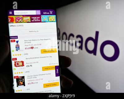 Stuttgart, Deutschland, 07.08.2023: Person, die ein Mobiltelefon hält, mit Website des britischen E-Commerce-Unternehmens Ocado Retail Limited auf dem Bildschirm mit Logo. Fokus Stockfoto