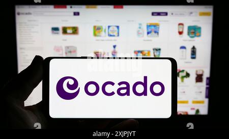 Stuttgart, Deutschland, 07.08.2023: Person, die ein Smartphone mit dem Logo des britischen E-Commerce-Unternehmens Ocado Retail Limited auf dem Bildschirm vor der Website hält. Stockfoto