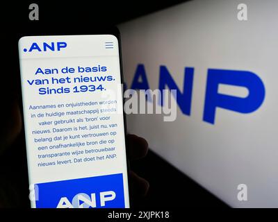 Stuttgart, Deutschland, 07.06.2023: Person, die ein Handy hält, mit Web-Seite von Algemeen Nederlands Persbureau B.V. (ANP) auf dem Bildschirm vor dem Logo. Fokus Stockfoto