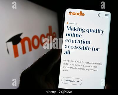 Stuttgart, Deutschland, 07.08.2023: Person, die ein Mobiltelefon hält, mit Webseite der Lernplattform Moodle vor dem Logo auf dem Bildschirm. Konzentrieren Sie sich auf die Mitte von Stockfoto