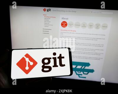 Stuttgart, Deutschland, 07.09.2023: Person, die ein Smartphone mit dem Logo des verteilten Versionskontrollsystems Git auf dem Bildschirm vor der Website hält. Konzentrieren Sie sich auf Stockfoto