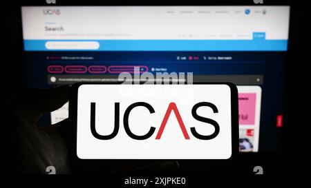 Stuttgart, Deutschland, 07.09.2023: Person, die ein Mobiltelefon mit dem Logo des Hochschulzugangsdienstes (UCAS) auf dem Bildschirm vor dem Internet hält Stockfoto