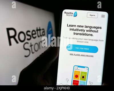 Stuttgart, Deutschland, 07.12.2023: Person, die ein Smartphone hält, mit Webseite des Bildungstechnologie-Unternehmens Rosetta Stone Inc. Auf dem Bildschirm mit Logo. Fokus Stockfoto