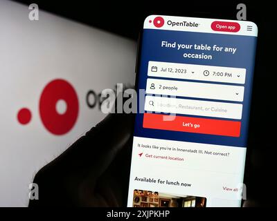 Stuttgart, Deutschland, 07.12.2023: Person, die ein Mobiltelefon hält, mit Webseite des US-amerikanischen Reservierungsdienstleisters OpenTable Inc. Auf dem Bildschirm mit Logo. Konzentrieren Sie sich auf Stockfoto
