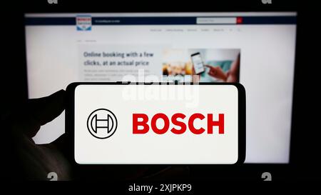 Stuttgart, 15.07.2023: Person mit Mobiltelefon mit Logo des deutschen Ingenieurunternehmens Robert Bosch GmbH auf dem Bildschirm vor der Webseite. Stockfoto