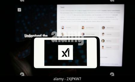 Stuttgart, 15.07.2023: Person, die ein Mobiltelefon mit dem Logo der amerikanischen Künstlichen Intelligenz-Firma XAI Corp. Auf dem Bildschirm hält Stockfoto