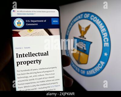 Stuttgart, Deutschland, 15.07.2023: Person, die ein Smartphone hält, mit Webseite des US-Handelsministeriums (DOC) auf dem Bildschirm mit Logo. Fokus Stockfoto