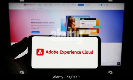 Stuttgart, Deutschland, 15.07.2023: Person, die ein Smartphone mit dem Logo des Softwareprodukts Adobe Experience Cloud (AEC) auf dem Bildschirm vor der Website hält. Stockfoto