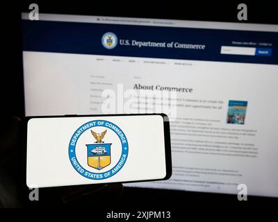 Stuttgart, 15.07.2023: Person, die ein Smartphone mit dem Siegel des US-Handelsministeriums (DOC) auf dem Bildschirm vor der Website hält. Stockfoto