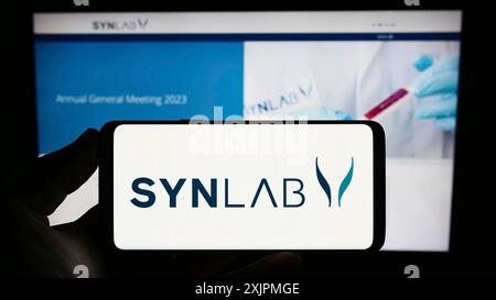 Stuttgart, 27.07.2023: Person mit Smartphone mit Logo des medizinischen Diagnostikunternehmens SYNLAB Group auf dem Bildschirm vor der Website. Fokus Stockfoto