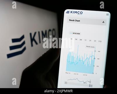 Stuttgart, Deutschland, 07-30-2023: Person, die ein Smartphone hält, mit Webseite der US-amerikanischen Immobiliengesellschaft Kimco Realty Corporation auf dem Bildschirm mit Logo. Fokus Stockfoto