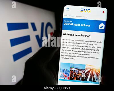 Stuttgart, Deutschland, 08.02.2023: Handybesitzer mit Website der union Eisenbahn- und Verkehrsgewerkschaft (EVG) auf dem Bildschirm mit Logo. Fokus Stockfoto