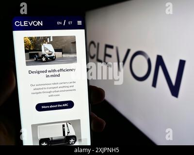 Stuttgart, Deutschland, 08.05.2023: Person, die ein Smartphone hält, mit Webseite des Estionian Autonomous Vehicle Company Clevon AS auf dem Bildschirm mit Logo. Fokus Stockfoto