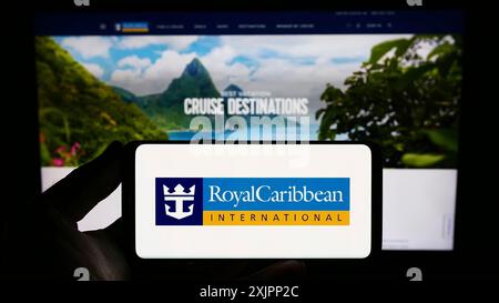 Stuttgart, Deutschland, 08.07.2023: Person, die ein Smartphone mit dem Logo der Firma Royal Caribbean International (RCI) auf dem Bildschirm vor der Website hält. Stockfoto