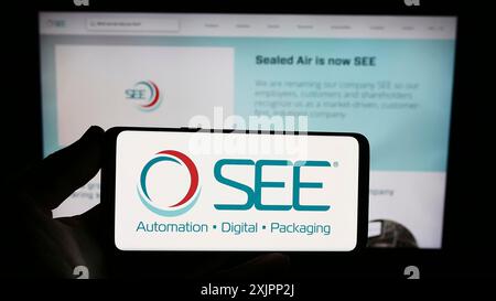 Stuttgart, Deutschland, 08.07.2023: Person, die ein Smartphone mit dem Logo des US-amerikanischen Verpackungsunternehmens Sealed Air Corporation (SIEHE) auf dem Bildschirm vor dem hält Stockfoto