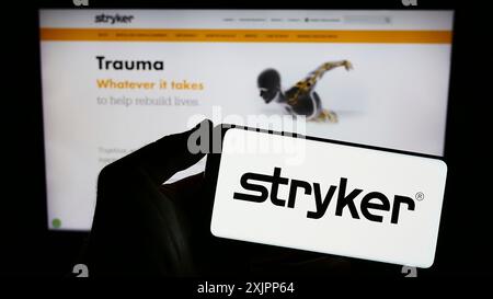 Stuttgart, Deutschland, 08.09.2023: Person mit Smartphone mit Logo des US-amerikanischen Medizintechnikunternehmens Stryker Corporation auf dem Bildschirm vor Stockfoto