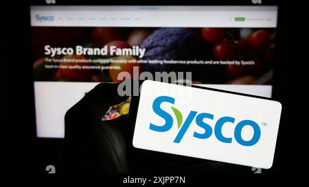 Stuttgart, Deutschland, 08.09.2023: Person, die ein Mobiltelefon mit dem Logo des US-Großhandelsunternehmens Sysco Corporation auf dem Bildschirm vor der Unternehmenswebseite hält. Stockfoto