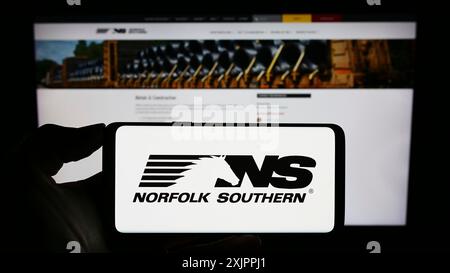 Stuttgart, 14.08.2023: Person, die ein Mobiltelefon mit dem Logo der US-amerikanischen Eisenbahngesellschaft Norfolk Southern Corp. Auf dem Bildschirm vor dem Firmenlogo hält. Stockfoto