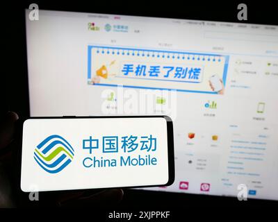 Stuttgart, Deutschland, 14.08.2023: Person, die ein Smartphone mit dem Logo des Telekommunikationsunternehmens China Mobile Limited auf dem Bildschirm vor der Website hält. Stockfoto